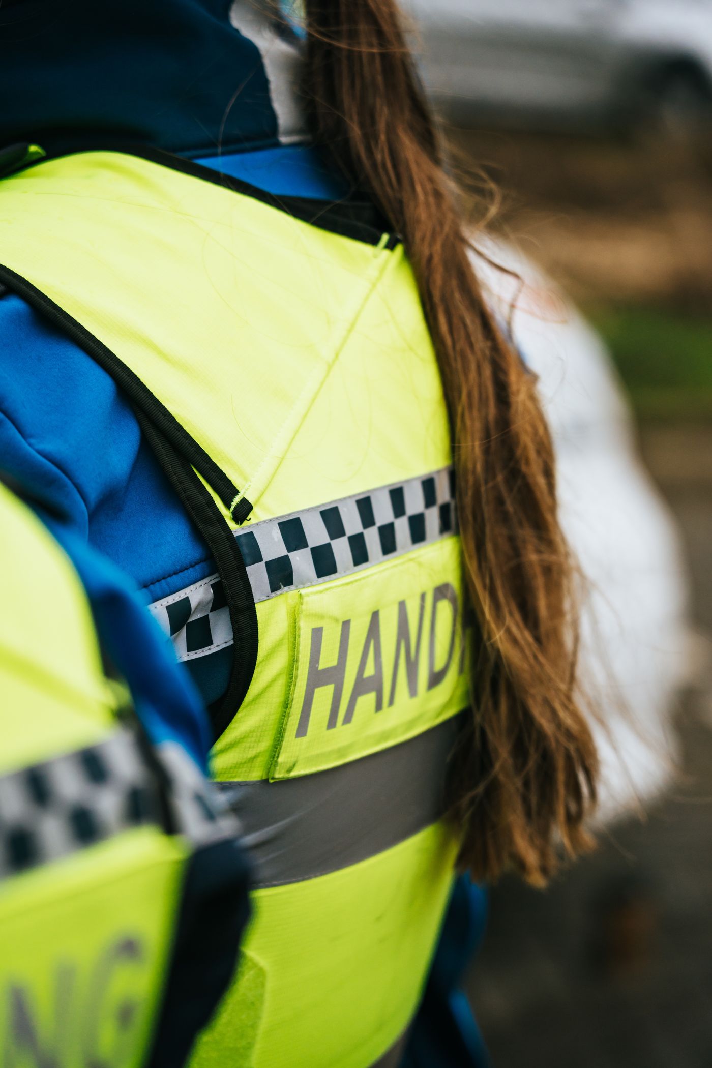 Handhaver in geel hesje met het opschrift handhaving