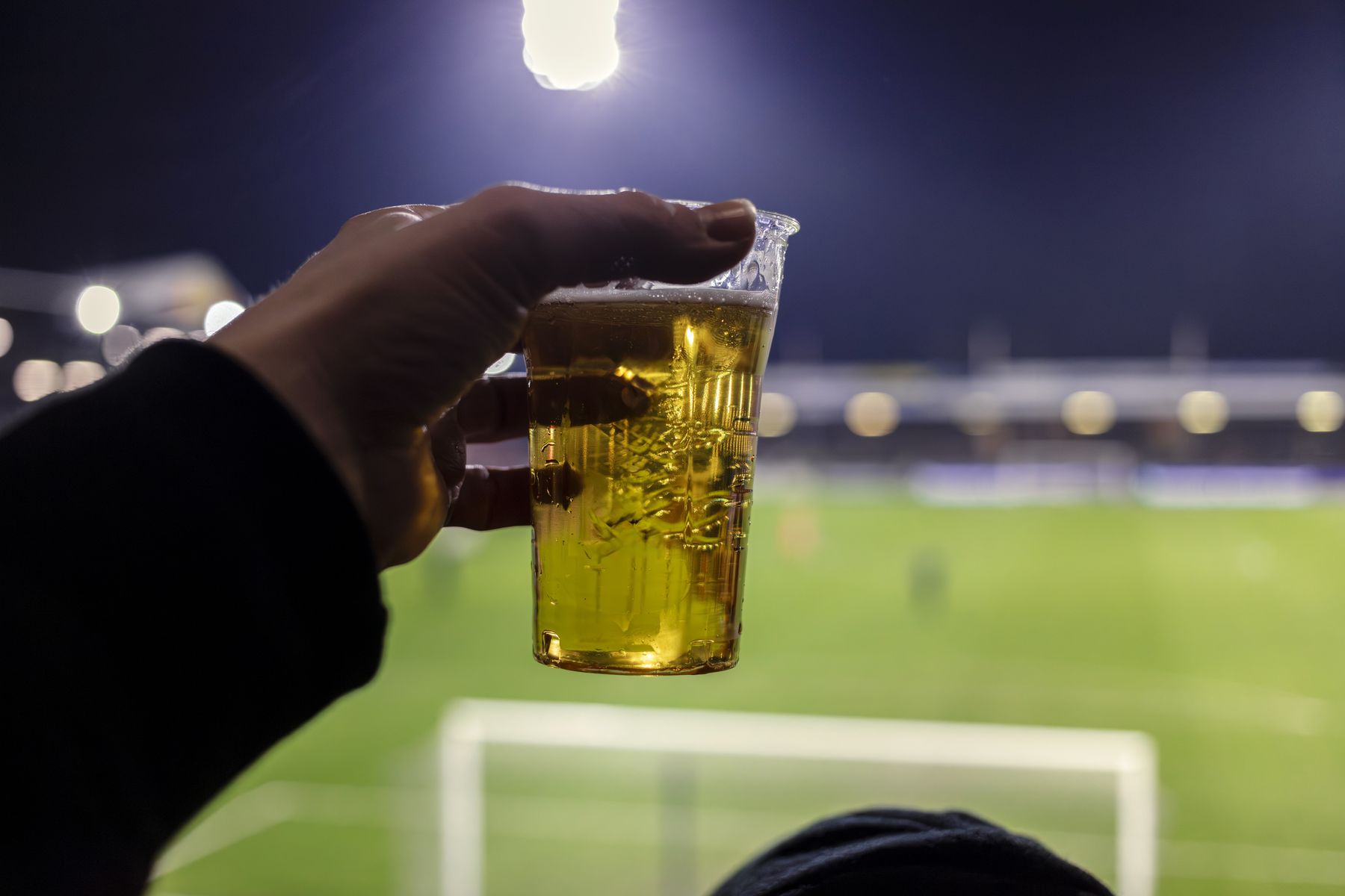 Bekertje bier voor een verlicht voetbalveld